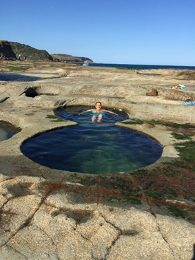 Ian from Sydney Coast Walks floating in Figure 8 Pools Sydney, Australia. No-one else is in the picture, he has Figure 8 Pool all to himself.